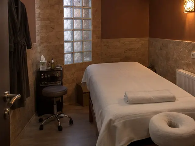 Taş duvarlı odada yüz yastıklı masaj masası — Bolluca, Masaj Salonun